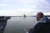 Mike looking out their rear balcony down the Mississippi at Carnival Ship leaving